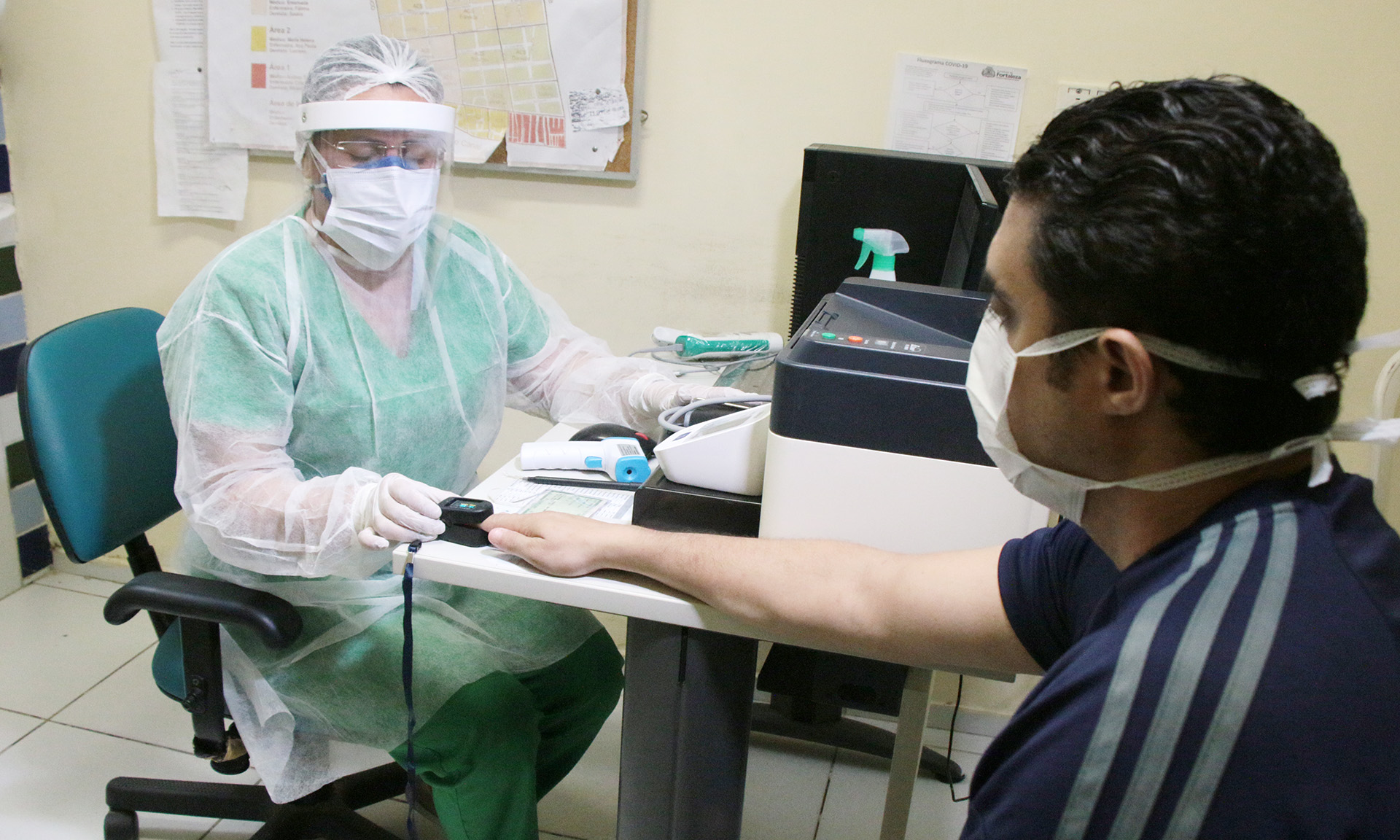 enfermeira coloca um oxímetro no dedo de um paciente